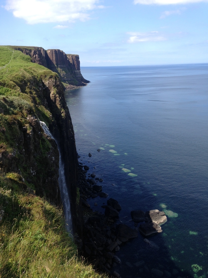 Des falaises surplombant la mer avec une cascade qui dévale.