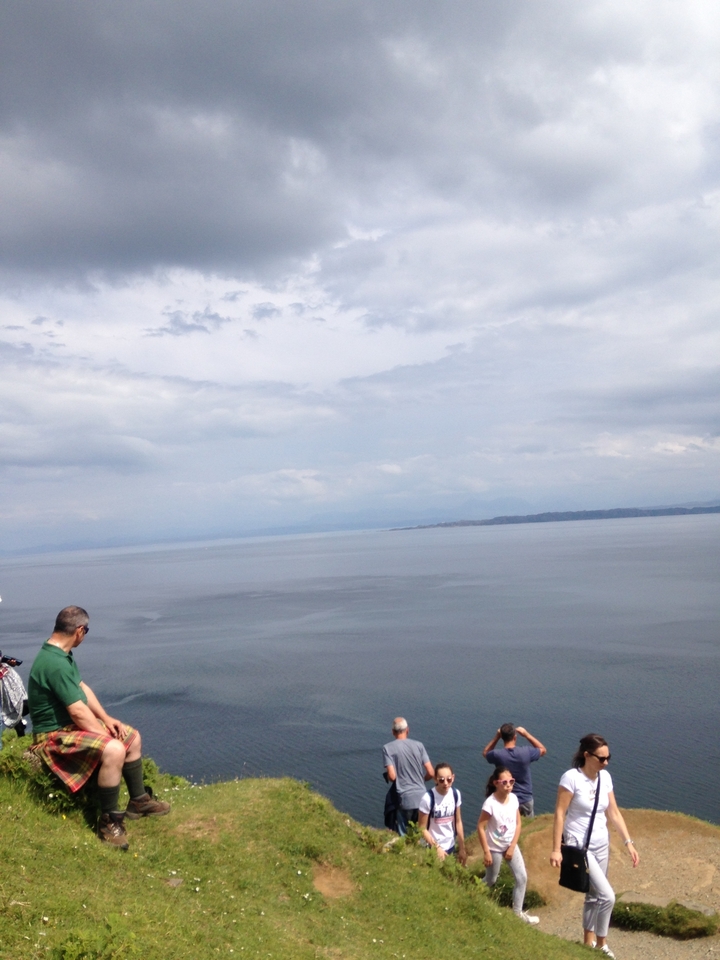 Homme regardant au loin par-dessus une vaste étendue d'eau avec de la terre à l'horizon.