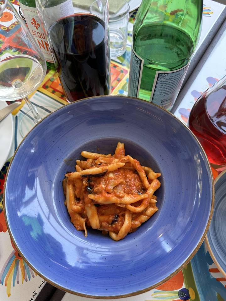 Un plat de pâtes servi avec de la sauce tomate dans un bol bleu.