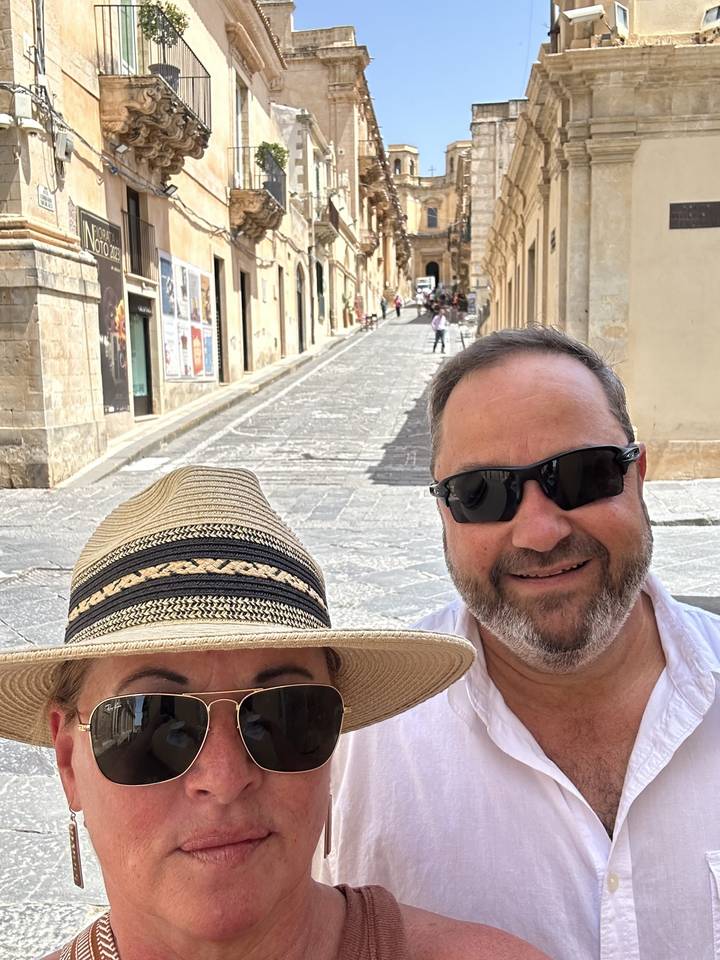 Deux personnes posant dans une rue avec des bâtiments historiques.
