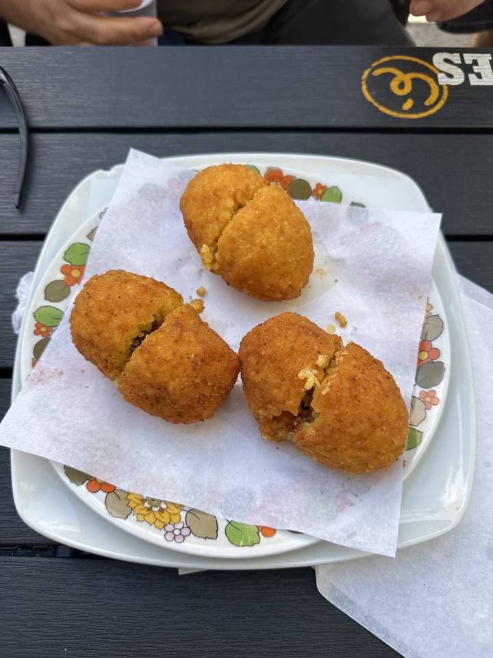 Quatre boulettes de riz frites sur une assiette décorative.