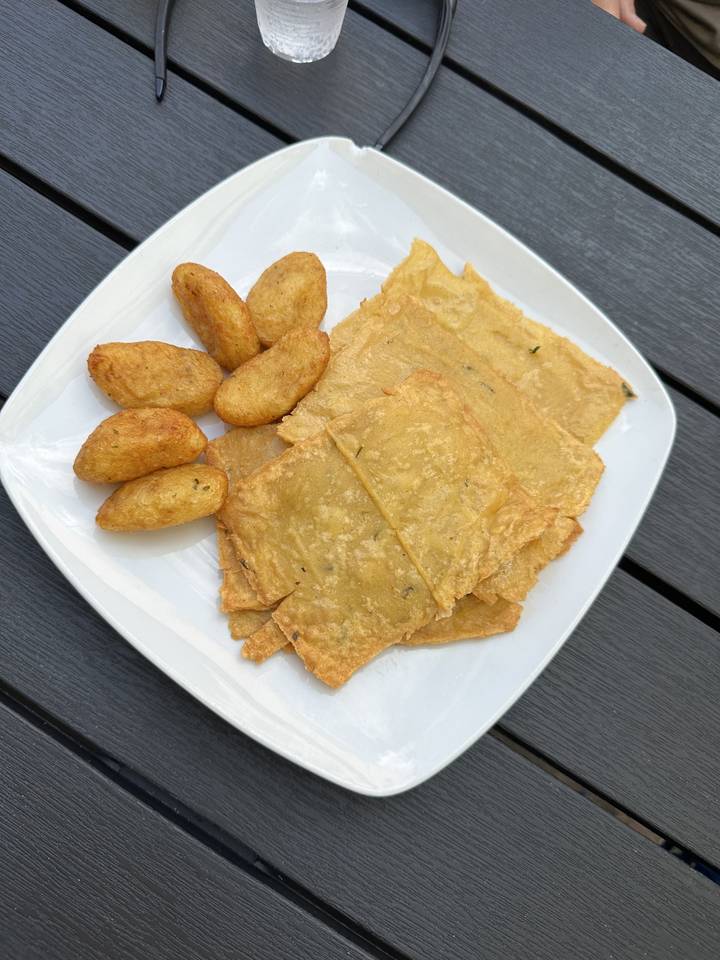Assiette avec de la nourriture frite et une bouteille d'eau sur une table en bois.