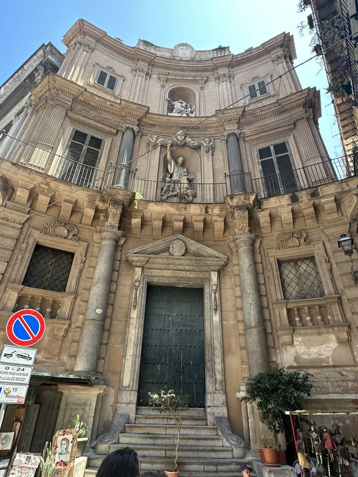 Façade d'ancien bâtiment avec sculptures à l'entrée.