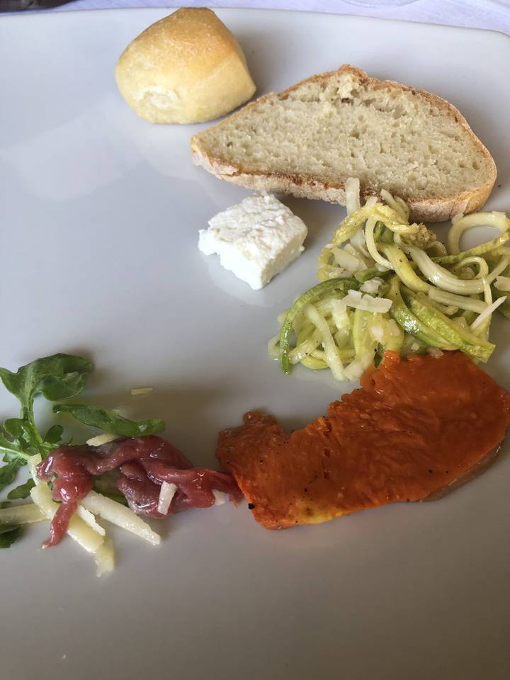 Une variété d'aliments sur une assiette, incluant du pain, du fromage et des légumes.