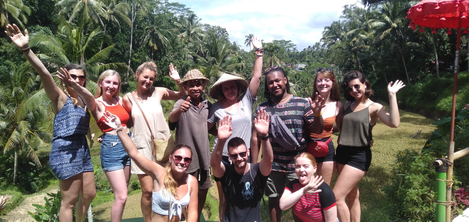 Group of people posing happily in a lush, tropical setting.