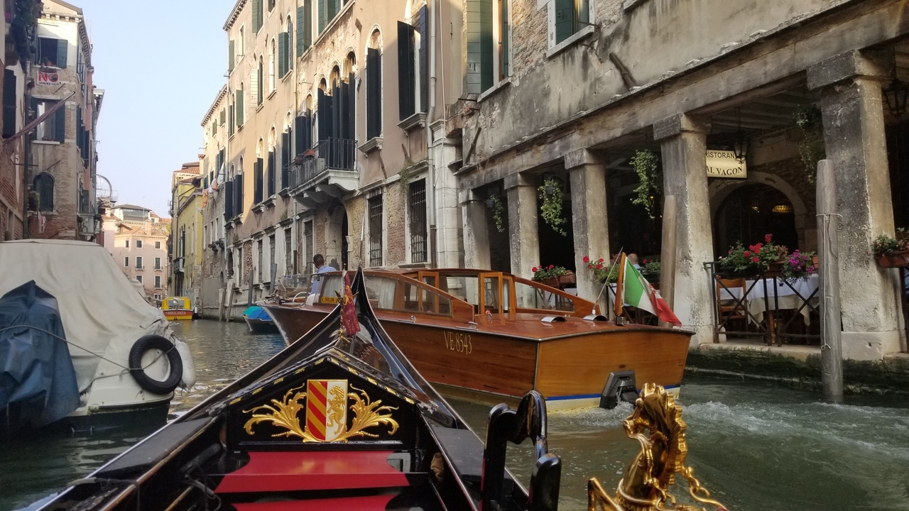 Un canal animé avec des bateaux et des bâtiments historiques bordant l'eau.