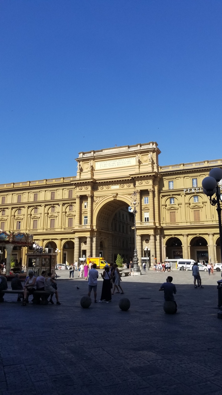 Une arche ornementée avec une architecture historique dans une ville européenne.