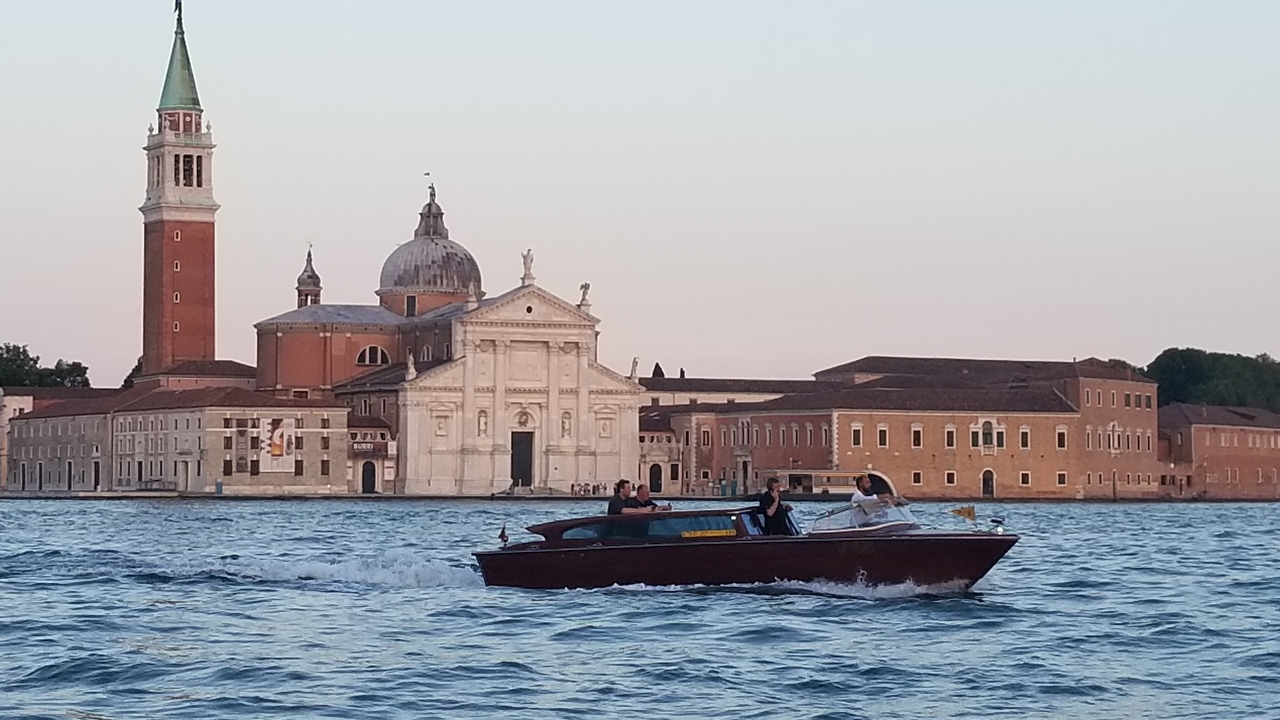 Une vue pittoresque d'une église au bord de l'eau avec un bateau qui passe.