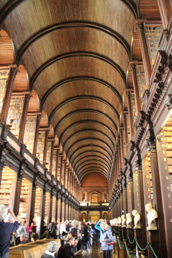 Intérieur d'une grande bibliothèque historique avec des arcs en bois.