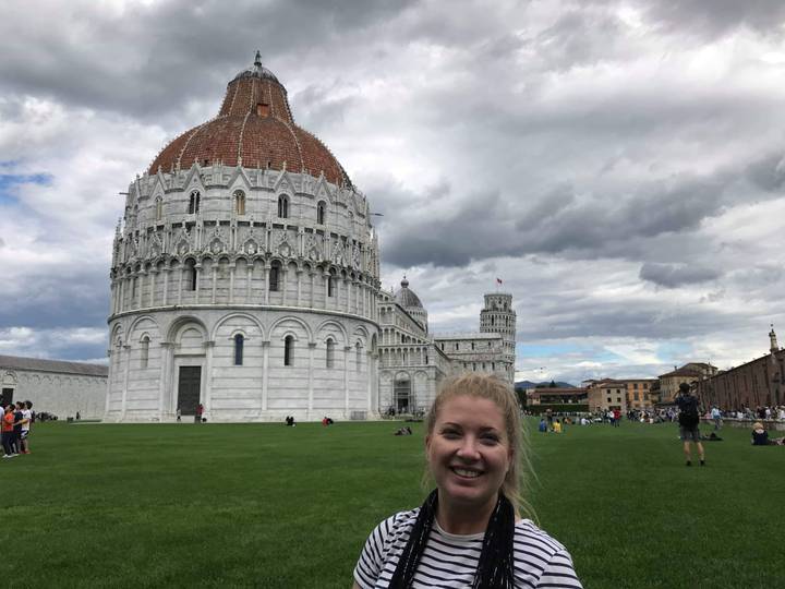 Person in front of the Pisa Cathedral and Leaning Tower.