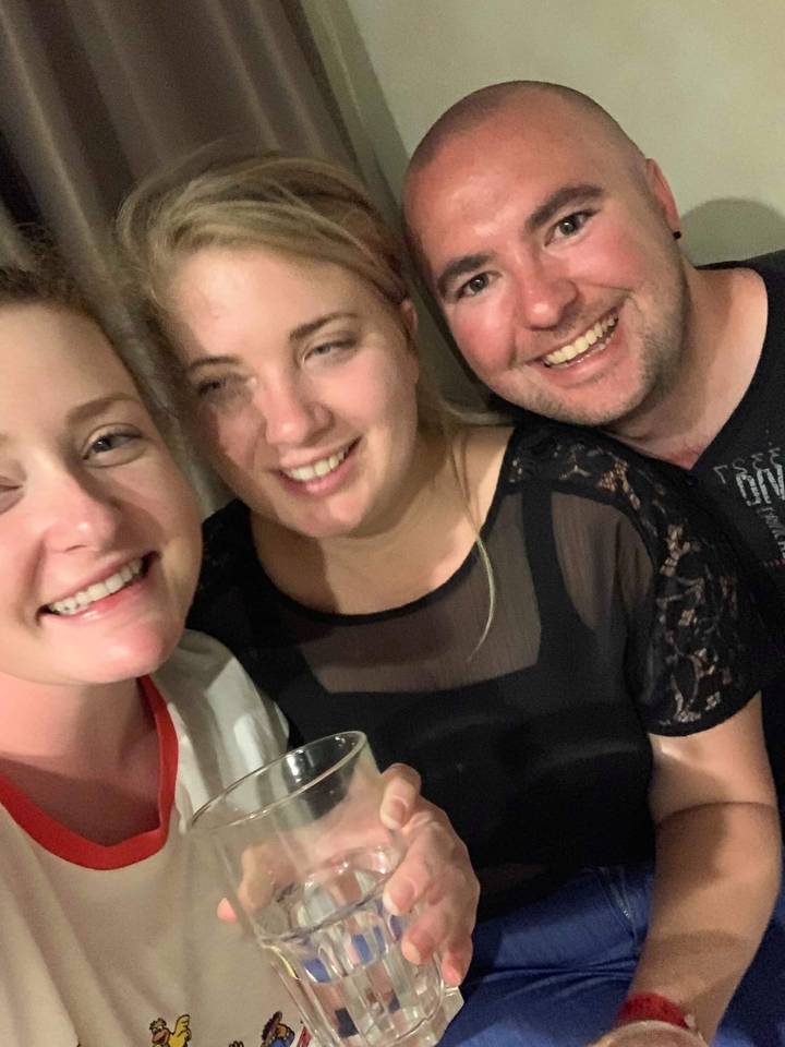 Three people taking a selfie indoors.