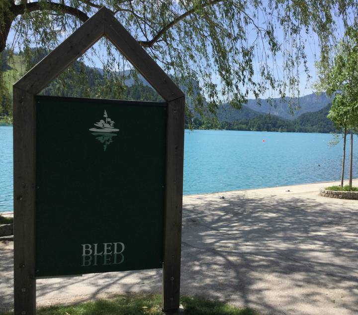 View of Lake Bled with a green sign in the foreground.