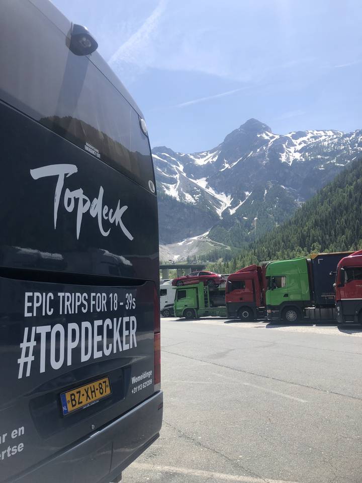 View of a mountainous landscape with vehicles and a tour bus.