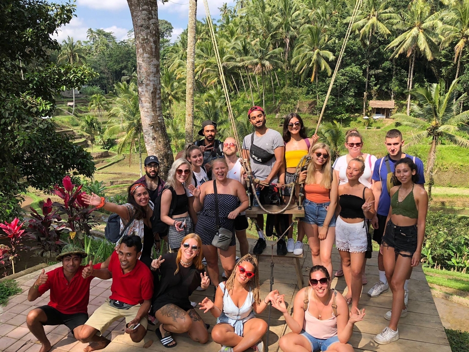 Group of people posing in a tropical landscape with rice terraces.