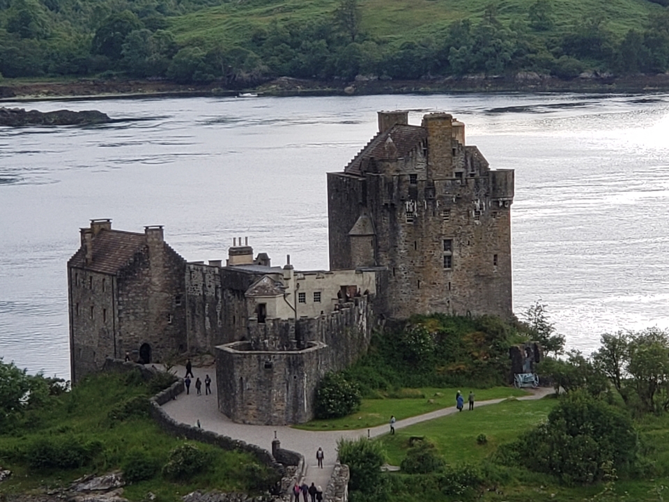 Medieval castle by the sea with a cloudy sky.