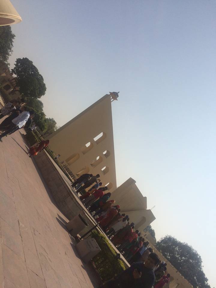 Un bâtiment avec une perspective inclinée avec des gens rassemblés à l'extérieur.