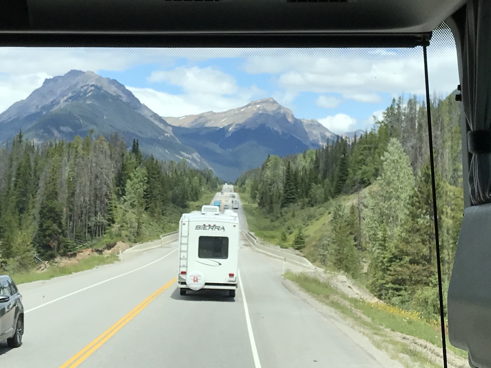 Route panoramique à travers un paysage montagneux avec des camping-cars.