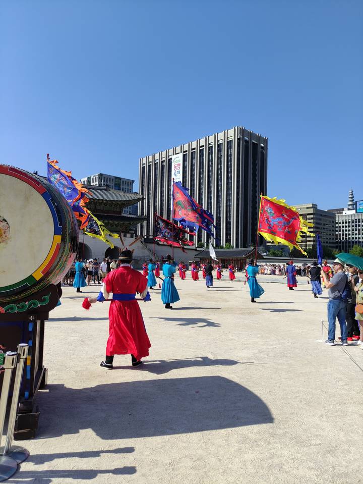 Défilé traditionnel avec des personnes en costumes d'époque portant des drapeaux.