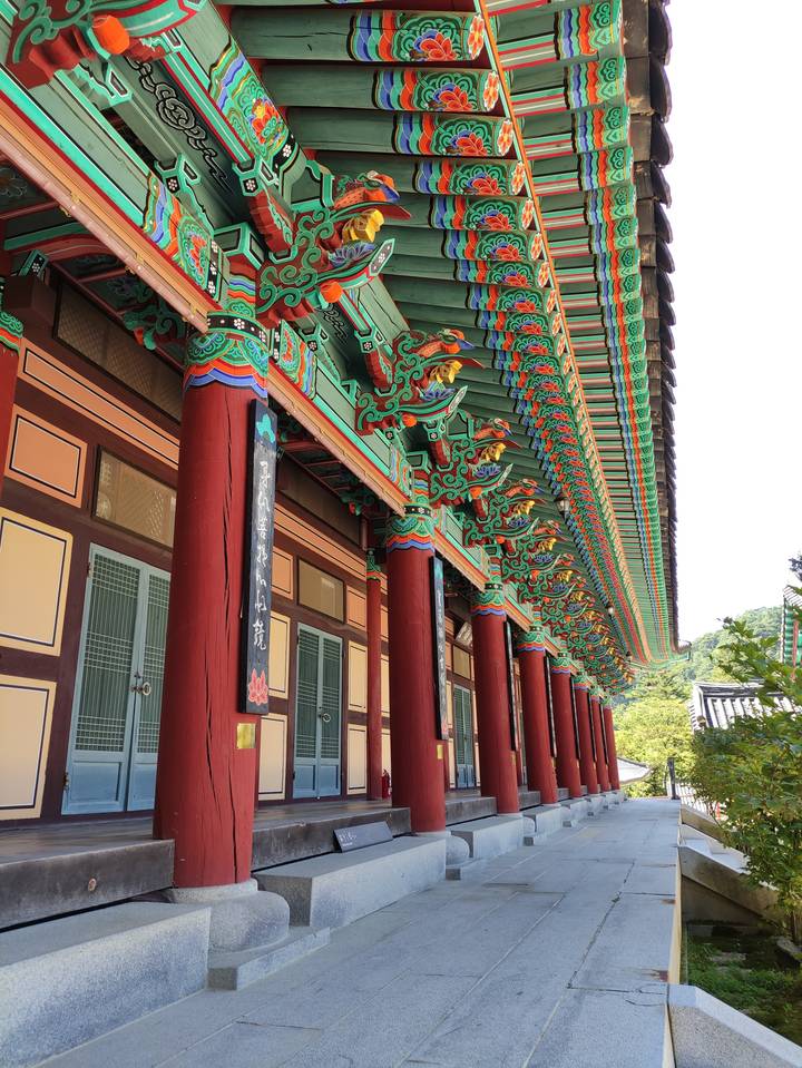 Architecture traditionnelle colorée avec des motifs complexes sur les poutres.