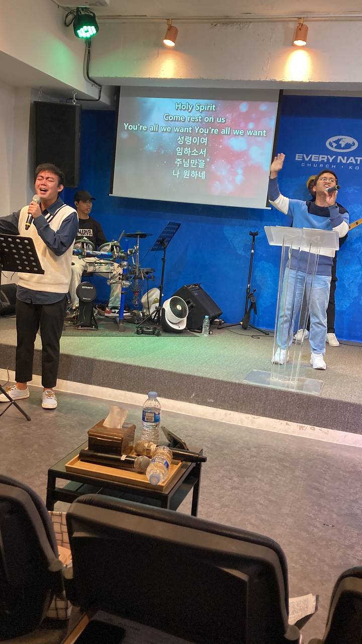 Des personnes qui chantent et jouent des instruments dans ce qui semble être une église ou un centre communautaire.