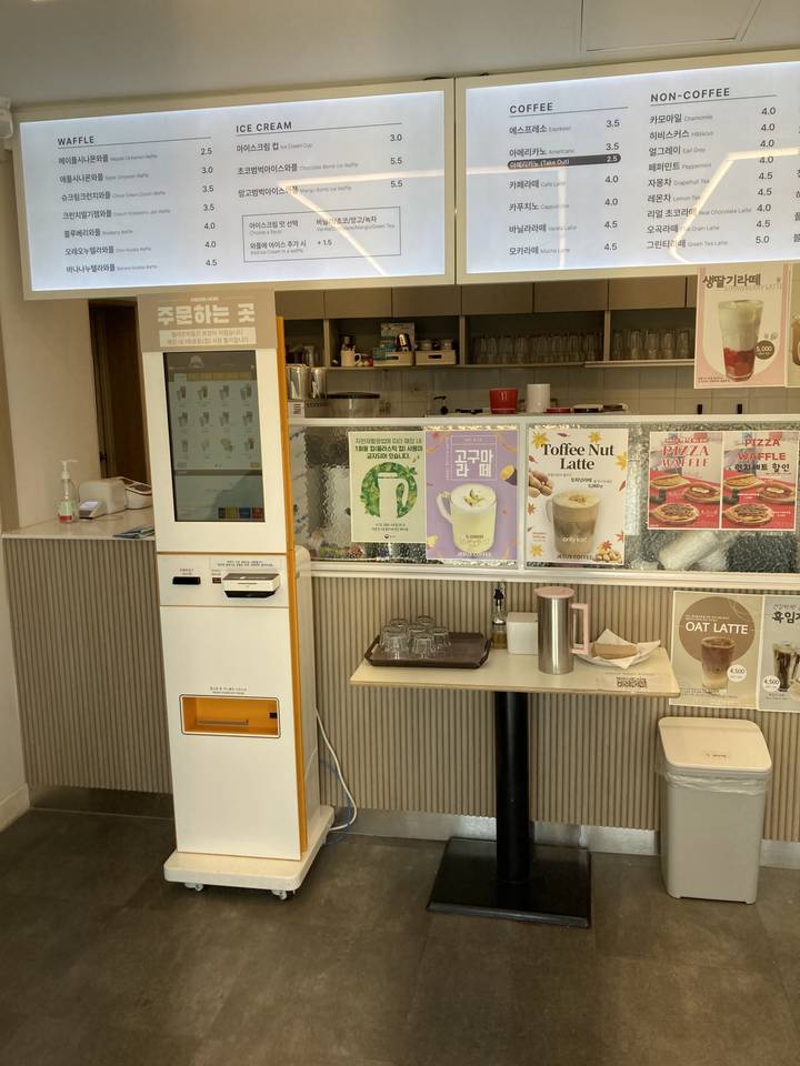 Une zone de café ou de distributeurs automatiques avec des menus et des bornes de commande.