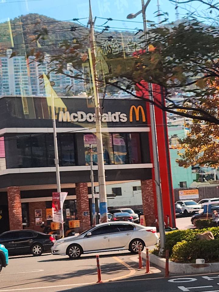 Bâtiment McDonald's avec une voiture garée devant.