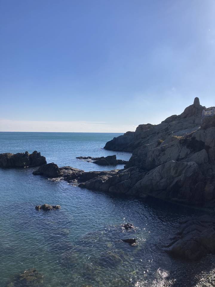 Côte rocheuse avec vue sur l'océan et ciel dégagé.