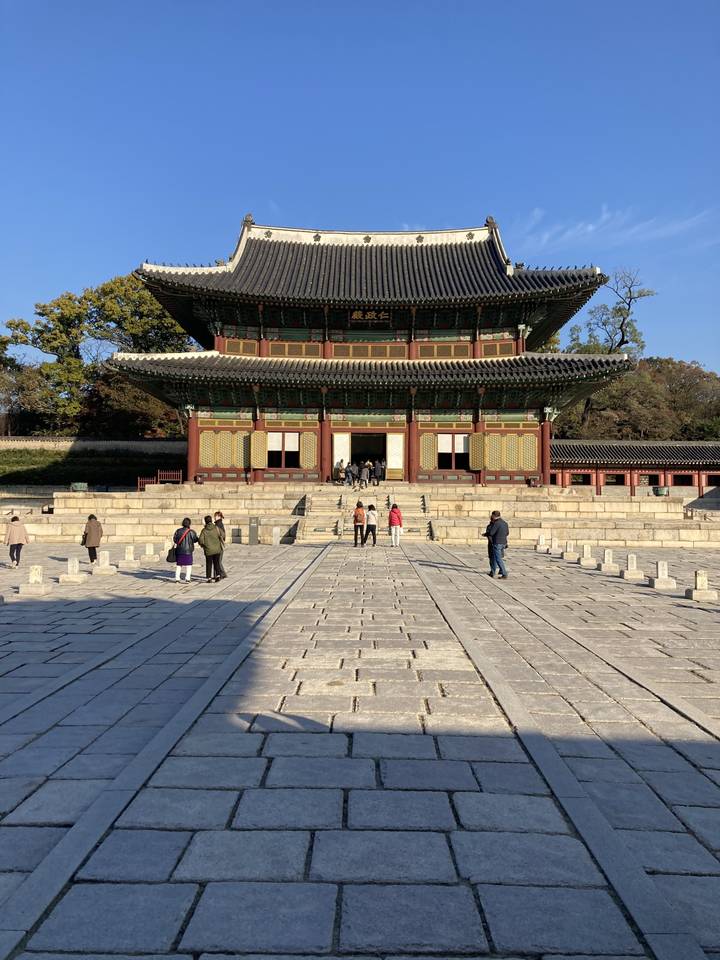 Portail de style traditionnel avec des gens qui passent devant.