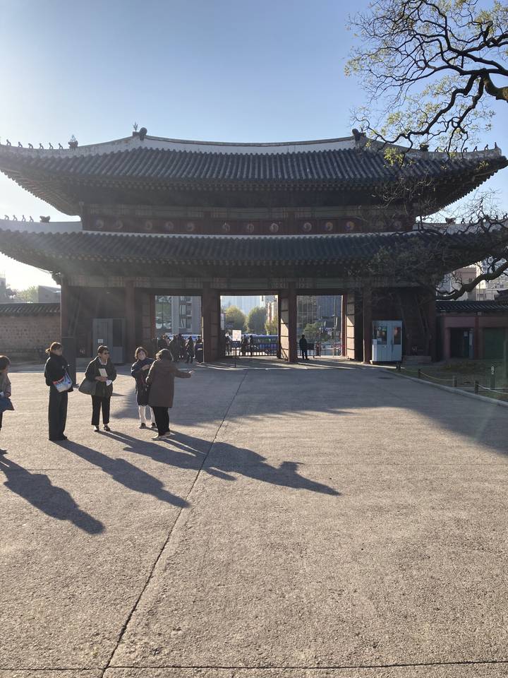 Entrée d'un bâtiment coréen traditionnel avec des personnes qui passent.