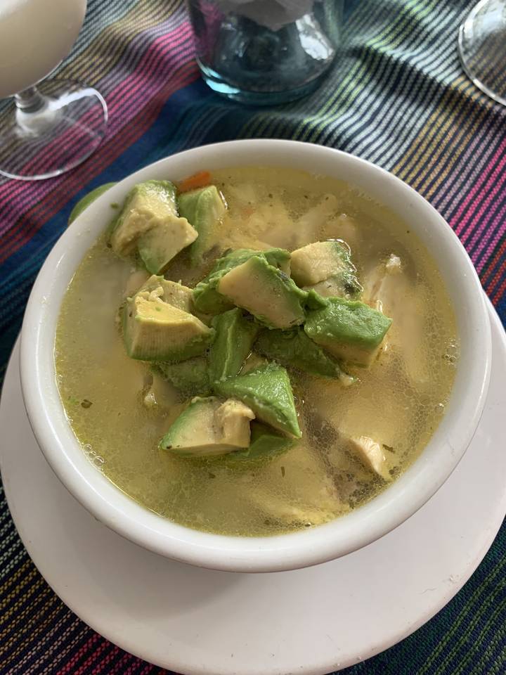 Un bol de soupe garni de morceaux d'avocat.