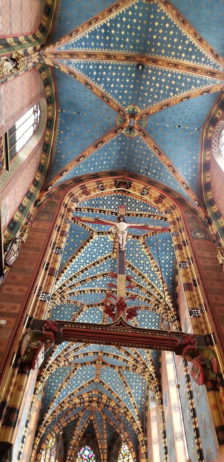 Intérieur de cathédrale richement décoré avec un crucifix.
