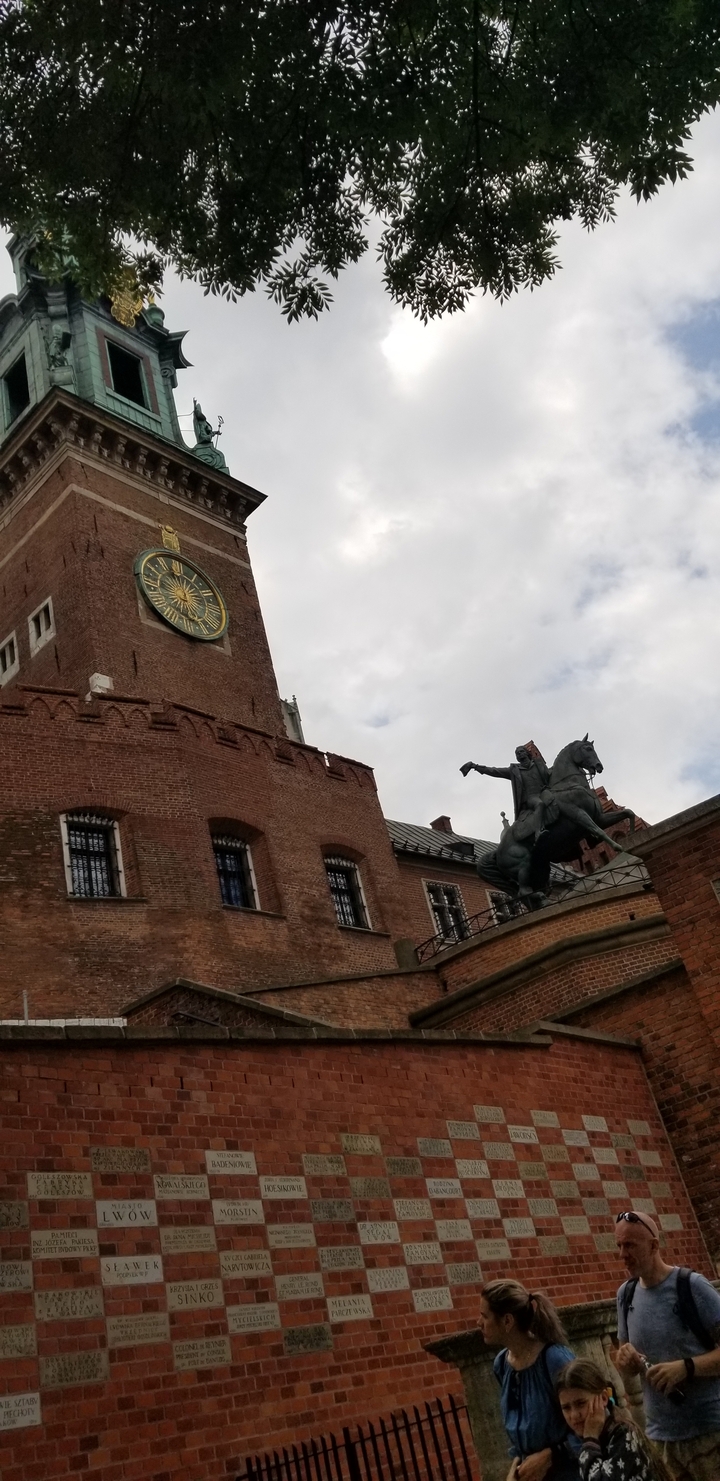 Statue équestre et bâtiment historique avec horloge.
