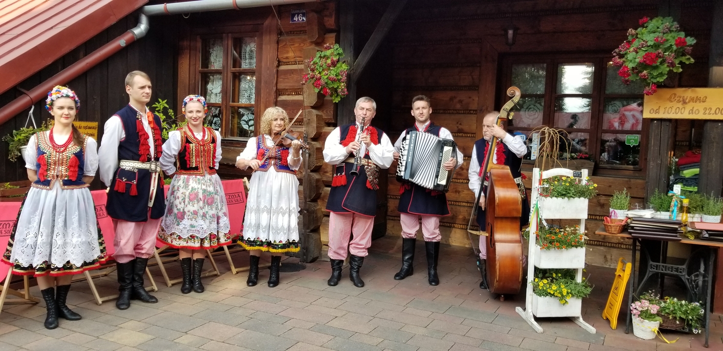 Musiciens traditionnels en costumes folkloriques colorés en plein air.