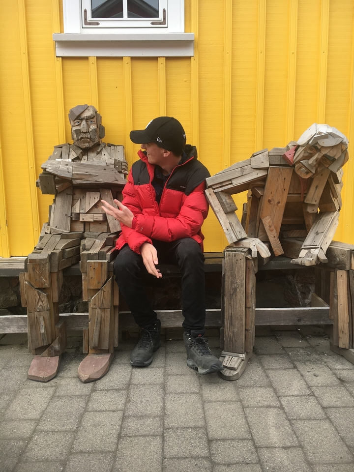 Personne assise avec des sculptures en bois