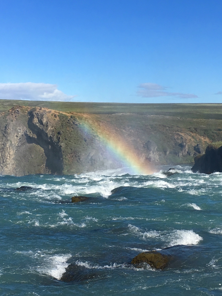Arc-en-ciel au-dessus d'une rivière avec des falaises