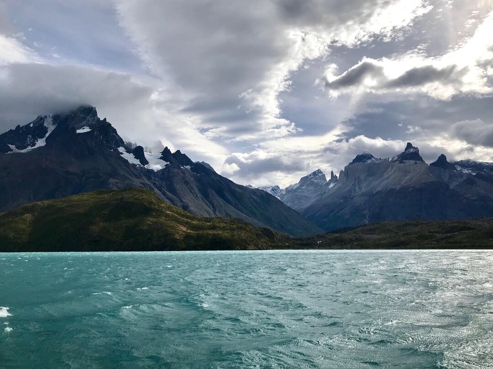 Étendue d'eau avec des montagnes en arrière-plan sous un ciel nuageux.