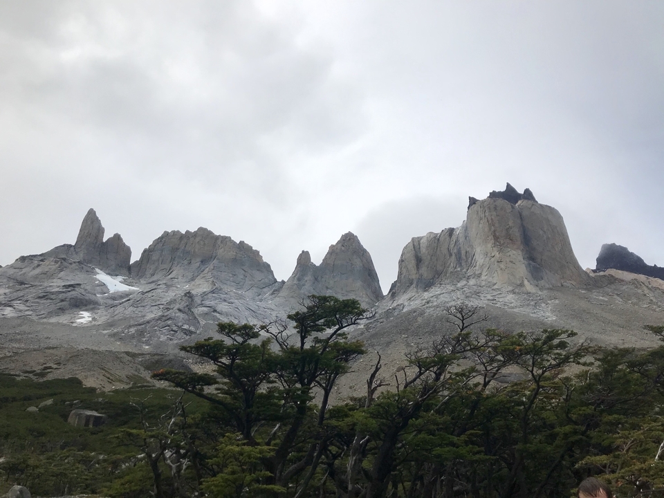 Sommets de montagnes avec un peu de neige contre un ciel gris.