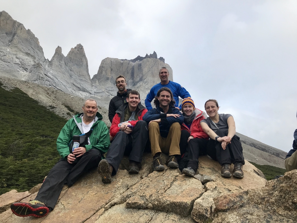 Groupe de personnes posant avec un paysage montagneux en arrière-plan.
