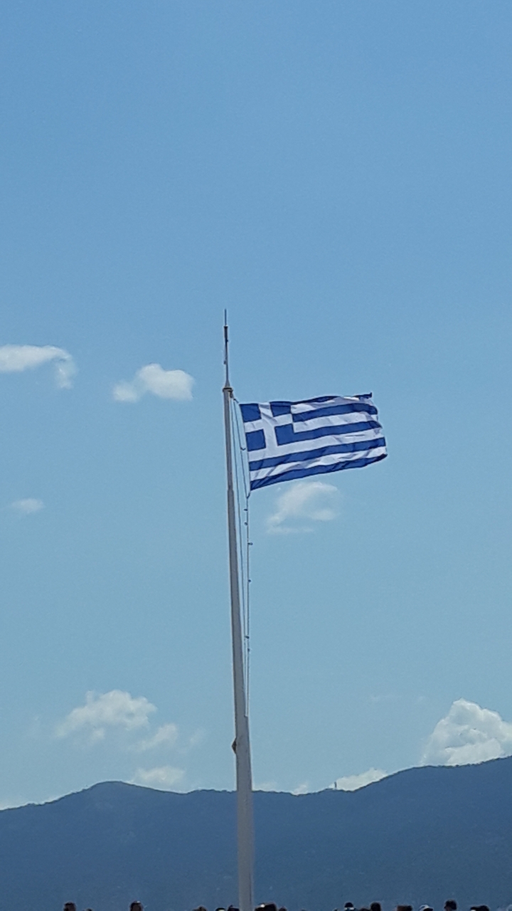 Drapeau grec flottant contre un ciel bleu.