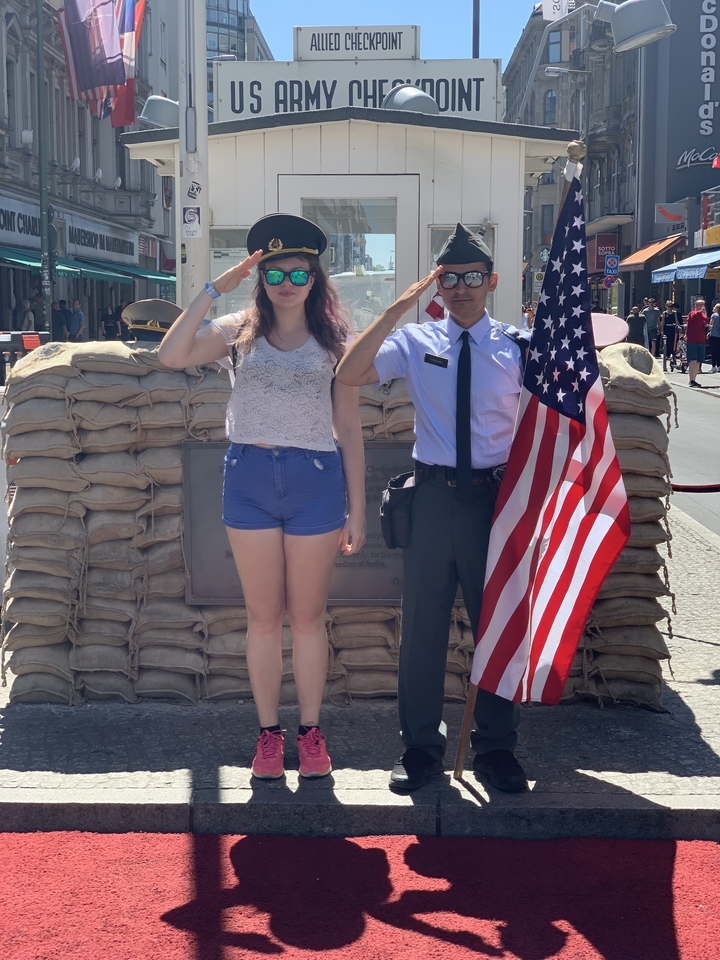 Des personnes posant à un point de contrôle avec un drapeau américain.