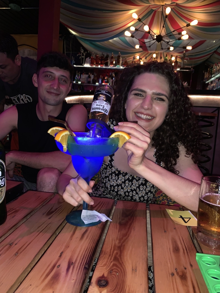 Des gens savourant un grand cocktail dans un bar.