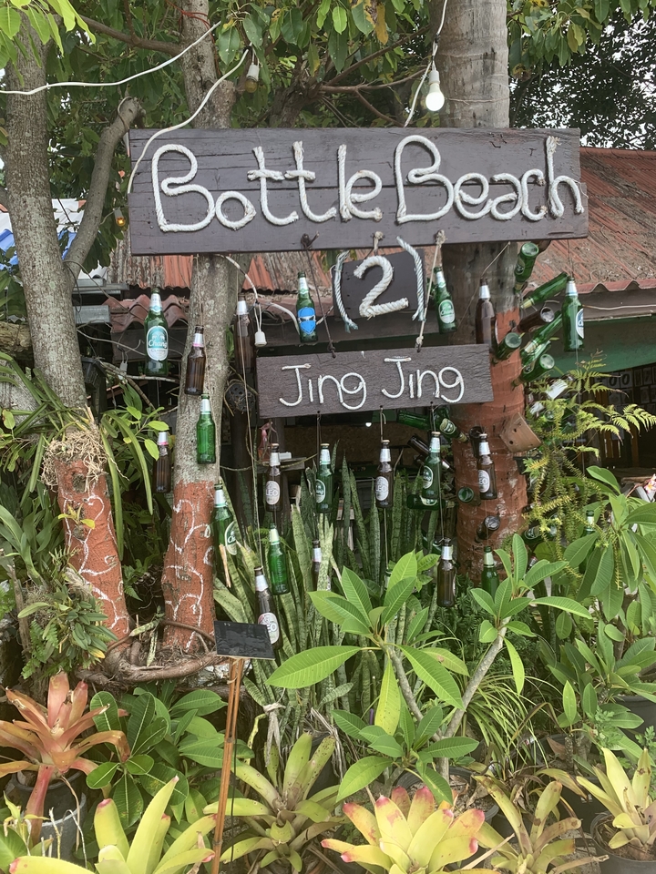 Panneau avec des bouteilles suspendues autour dans un jardin.