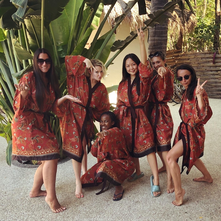 Women in traditional dress posing together outdoors.