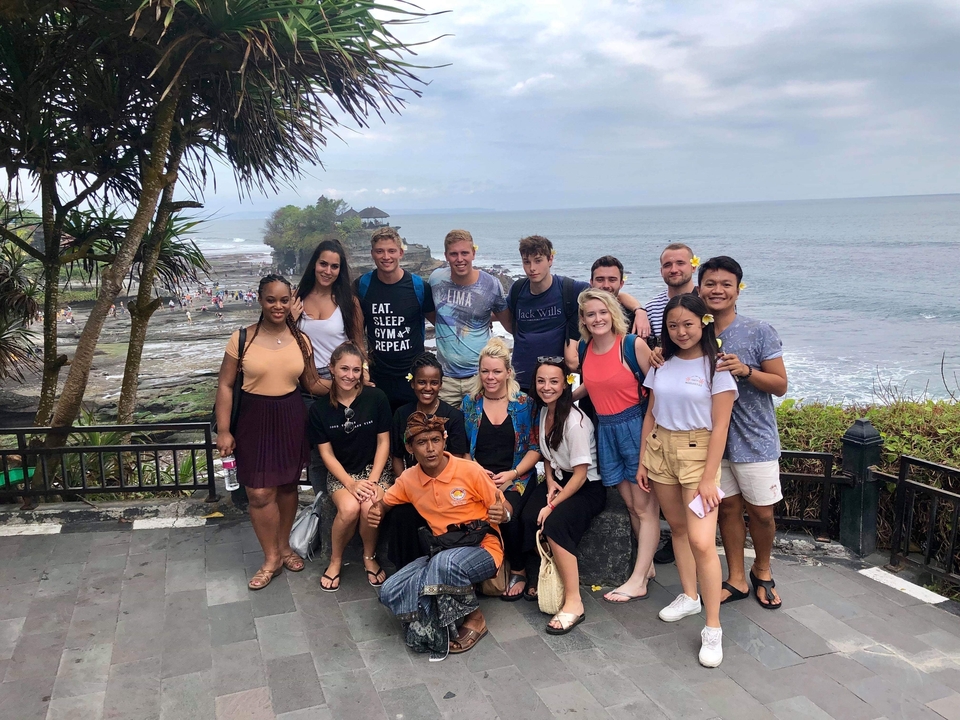 Crowd posing by a coastal viewpoint.