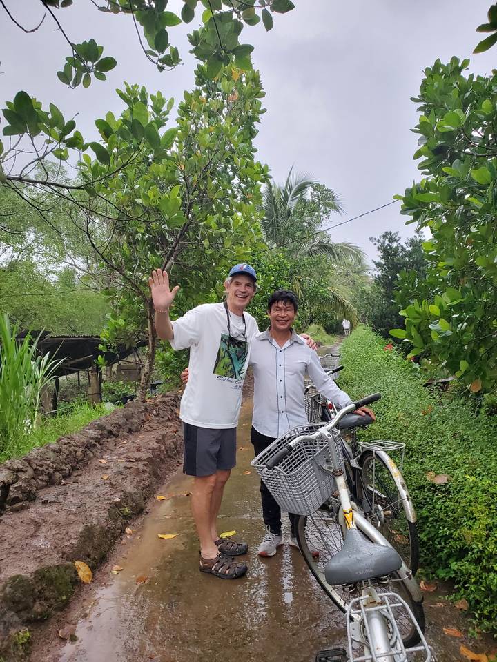 Deux personnes souriantes à l'extérieur avec des vélos.
