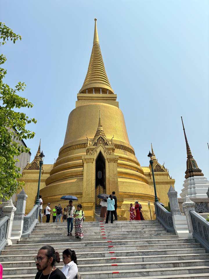 Stupa doré avec des gens autour.