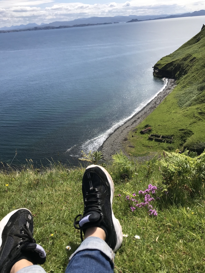 Vue d'un littoral depuis une falaise herbeuse.