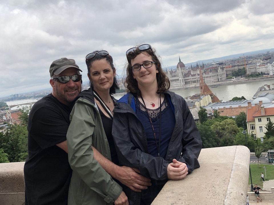 Famille posant avec vue sur une grande rivière et une ville.