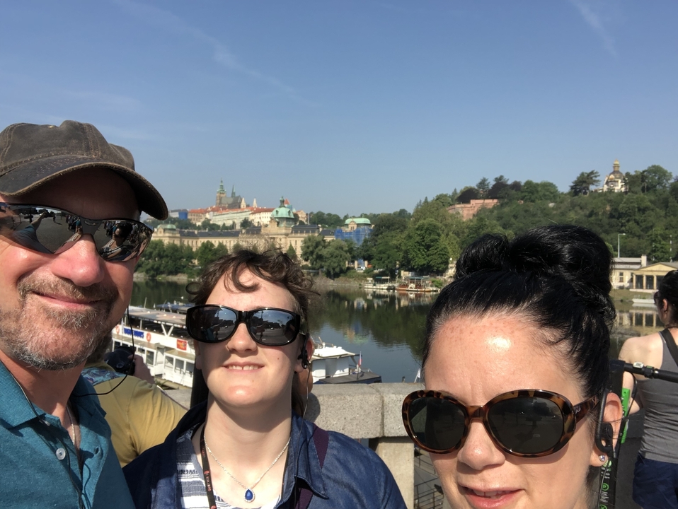 Des personnes posant sur un pont avec des bâtiments historiques en arrière-plan.