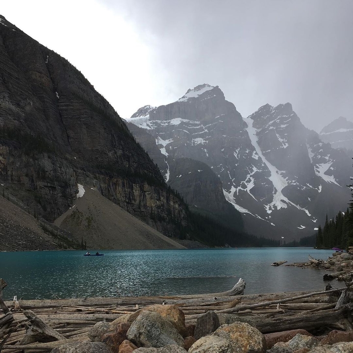 Turquoise lake surrounded by towering snowy mountains.